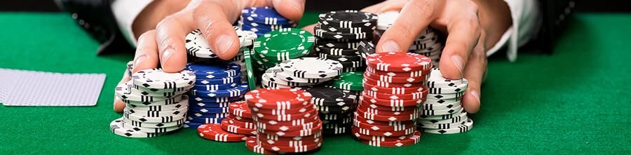 person pushing poker chips on a poker table