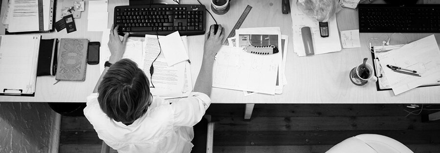 black and white photo from a birdseye view of a person working at their desk