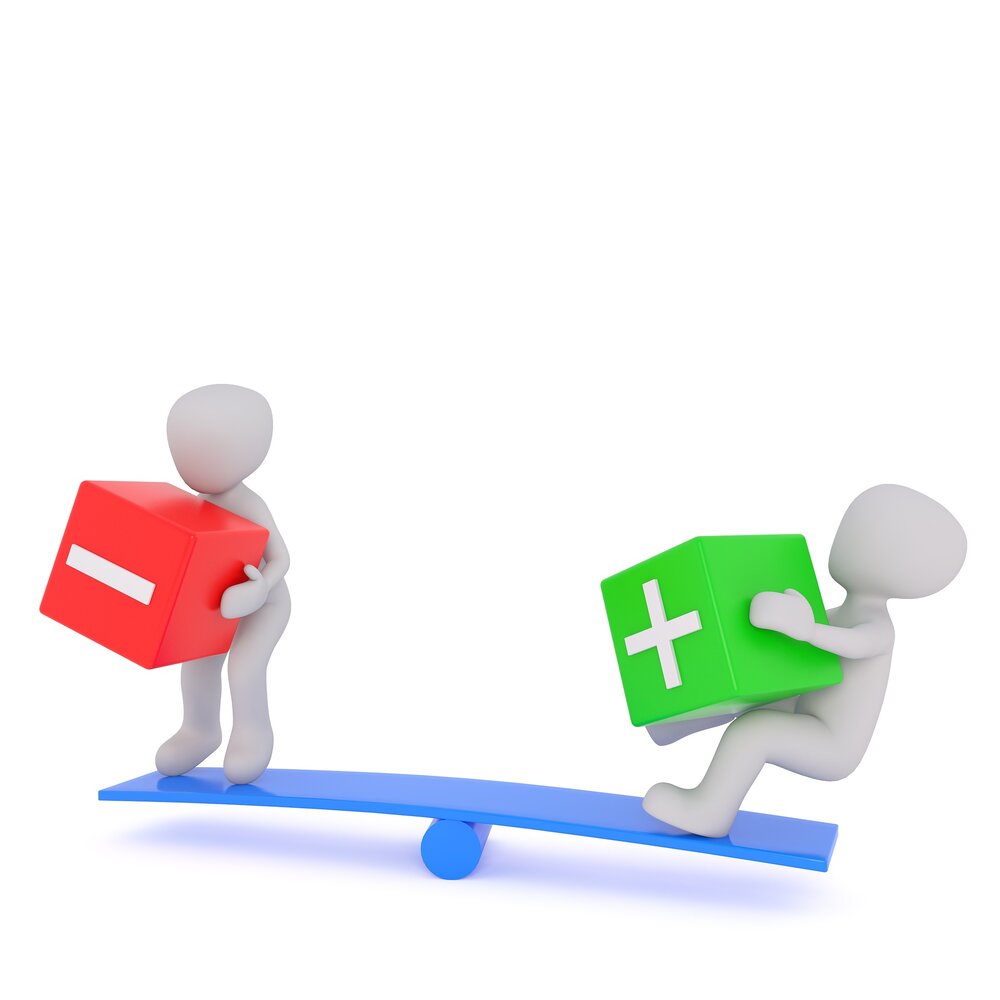 imaginary people on a blue see-saw. One holding a red box with a minus sign. The other holding a green box with a plus sign